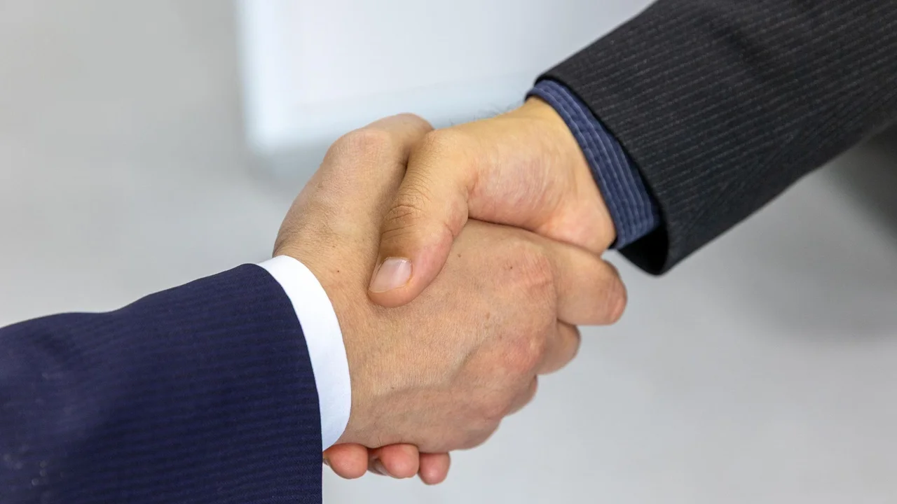 開発会社の担当者と握手する発注者